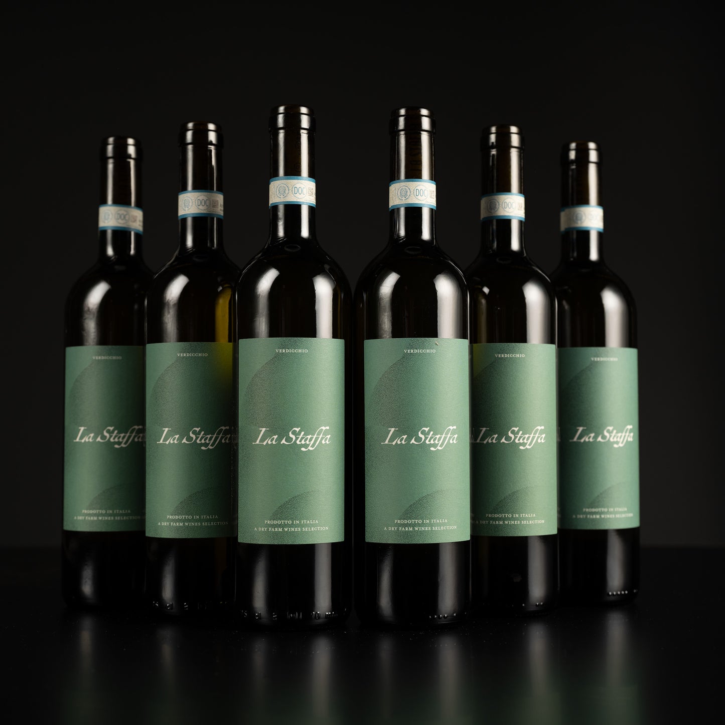 Seven bottles of La Staffa wine arranged in a row on a black background