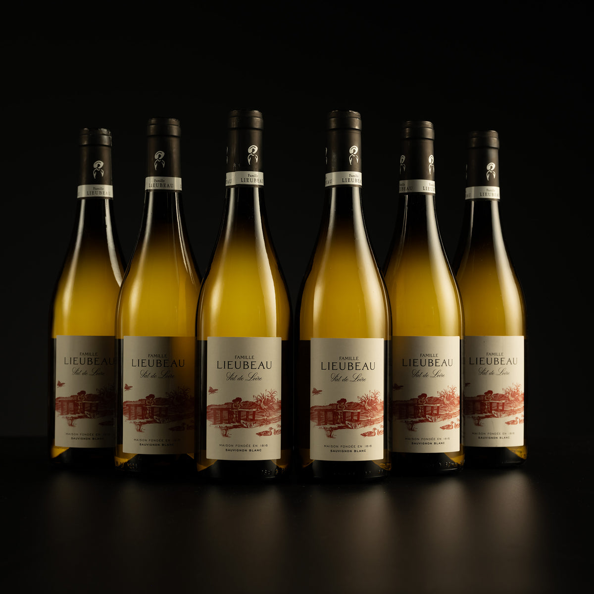 Six bottles of Lieubeau wine arranged in a row on a black background