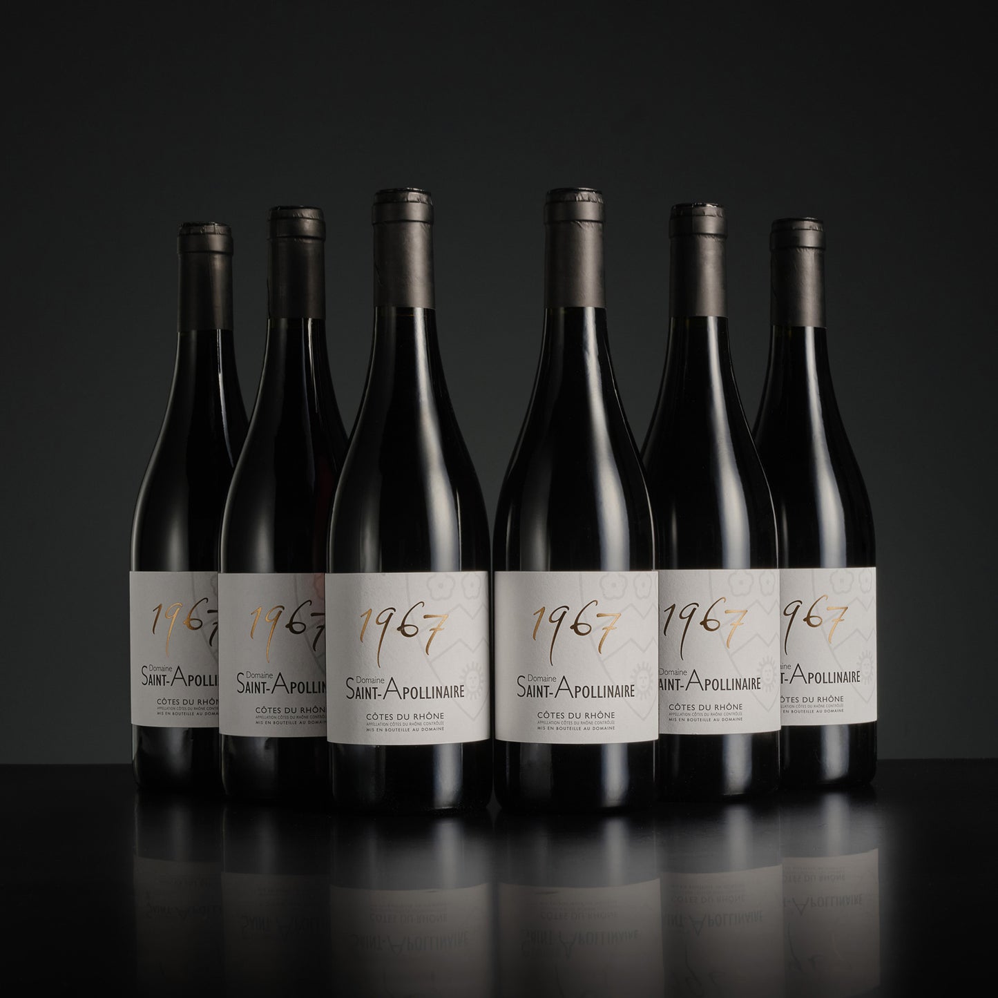 eight bottles of 1967 Saint-Apollinaire wine on a black background