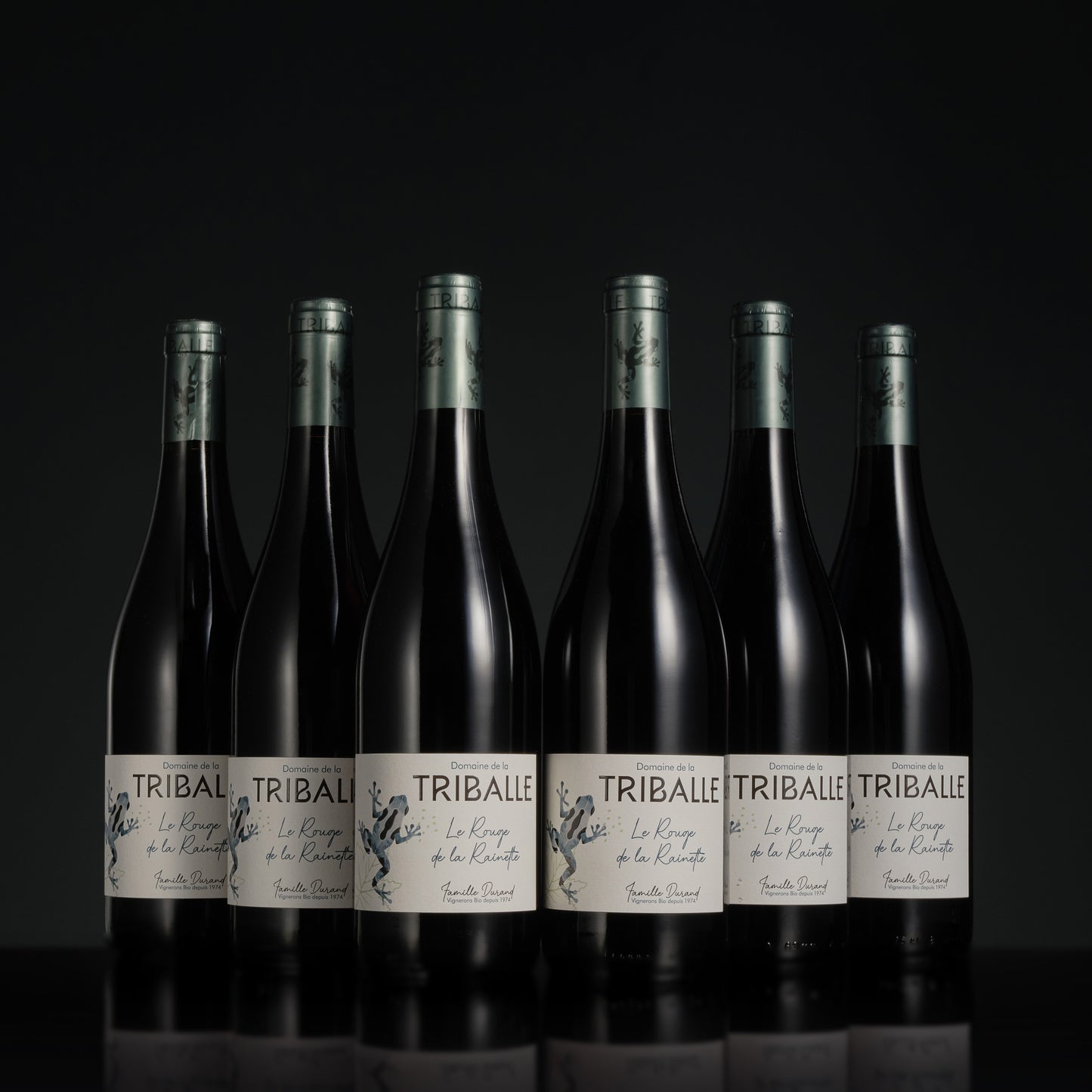 Row of Tribale wine bottles on a black background