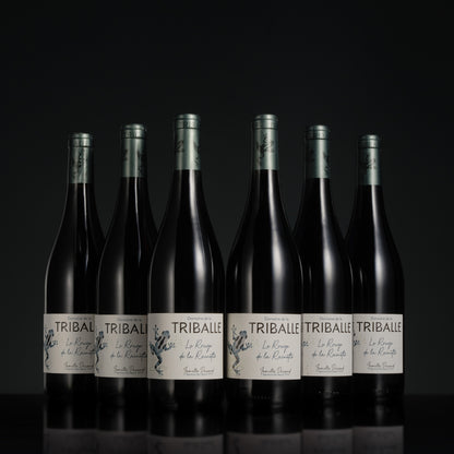 Row of Tribale wine bottles on a black background
