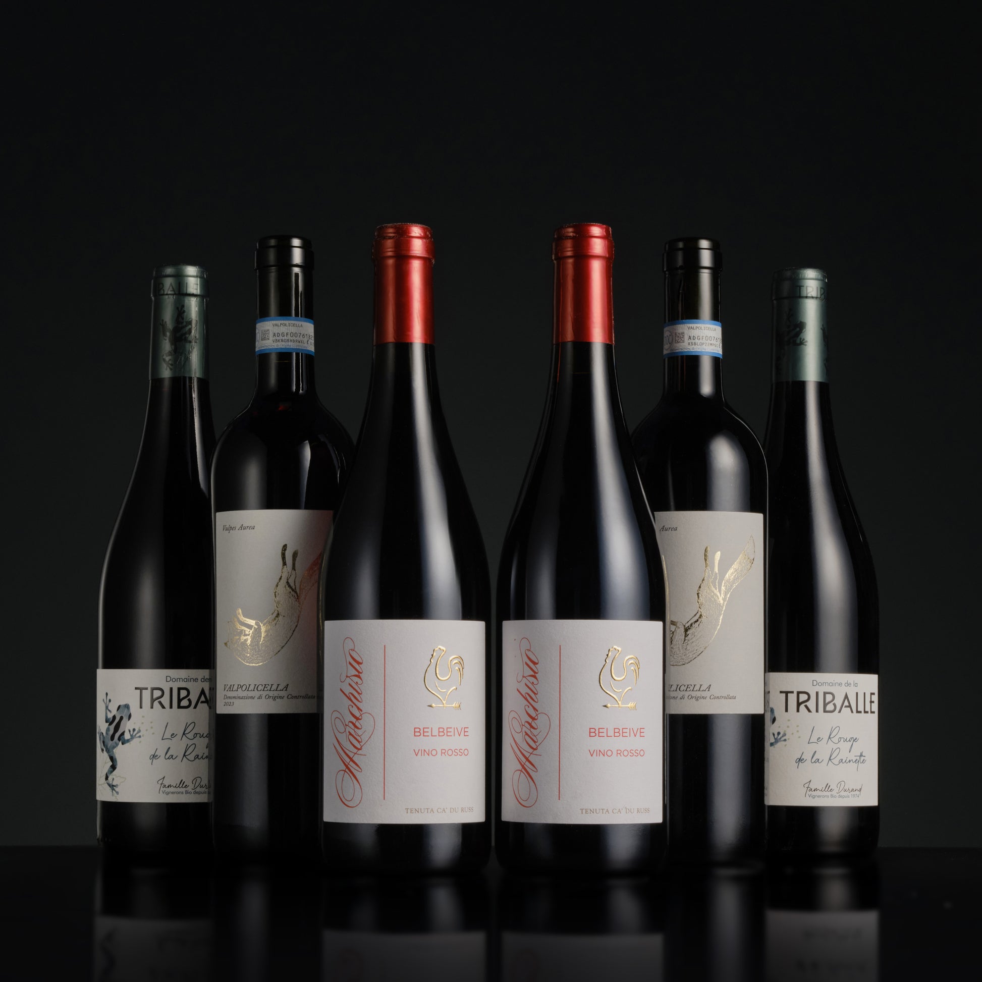 Collection of wine bottles with visible labels on a black background