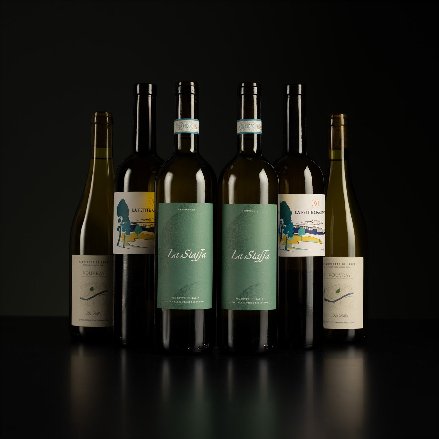 Collection of wine bottles with visible labels on a dark background