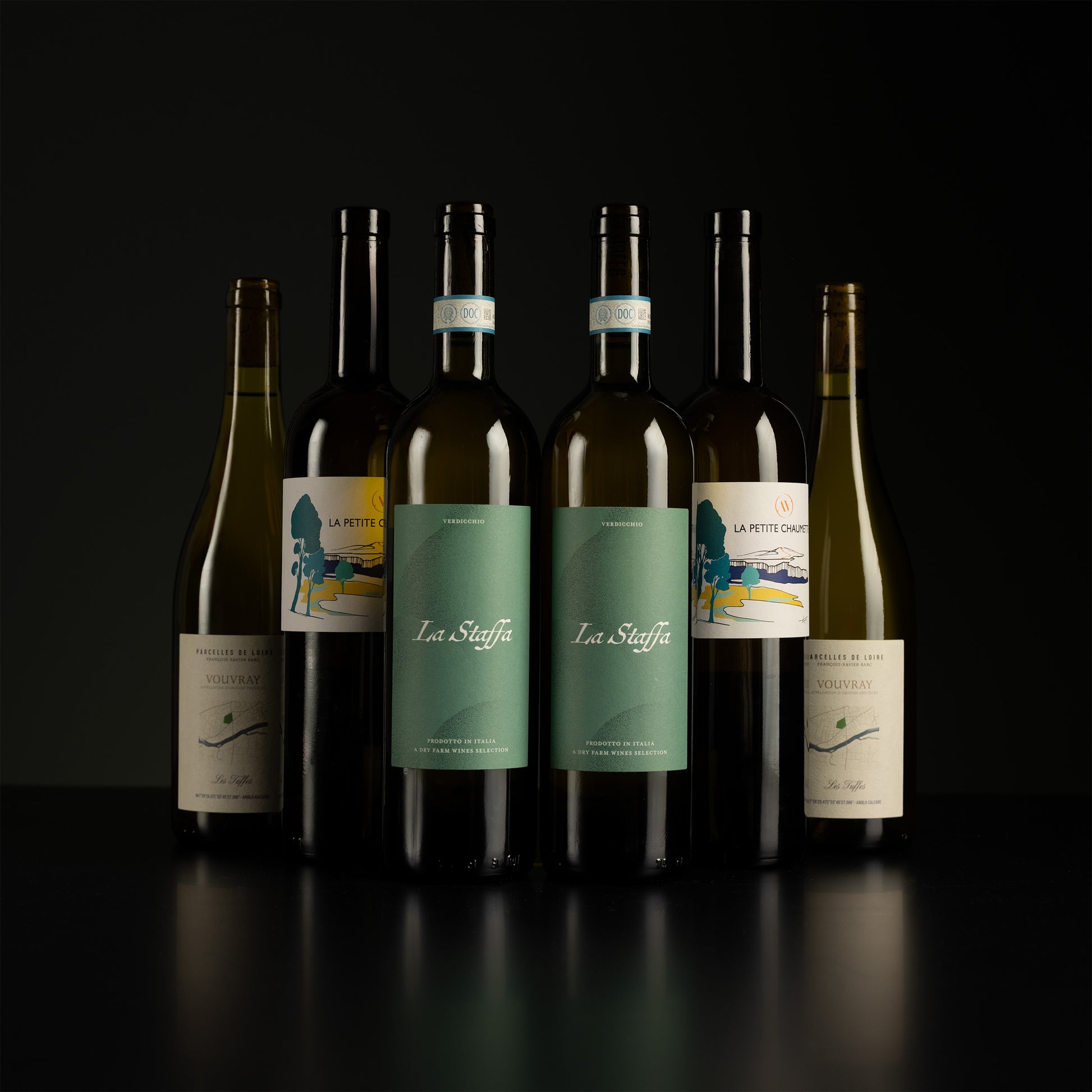 Collection of wine bottles with visible labels on a dark background
