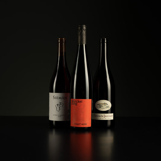 Three wine bottles with labels on a black background