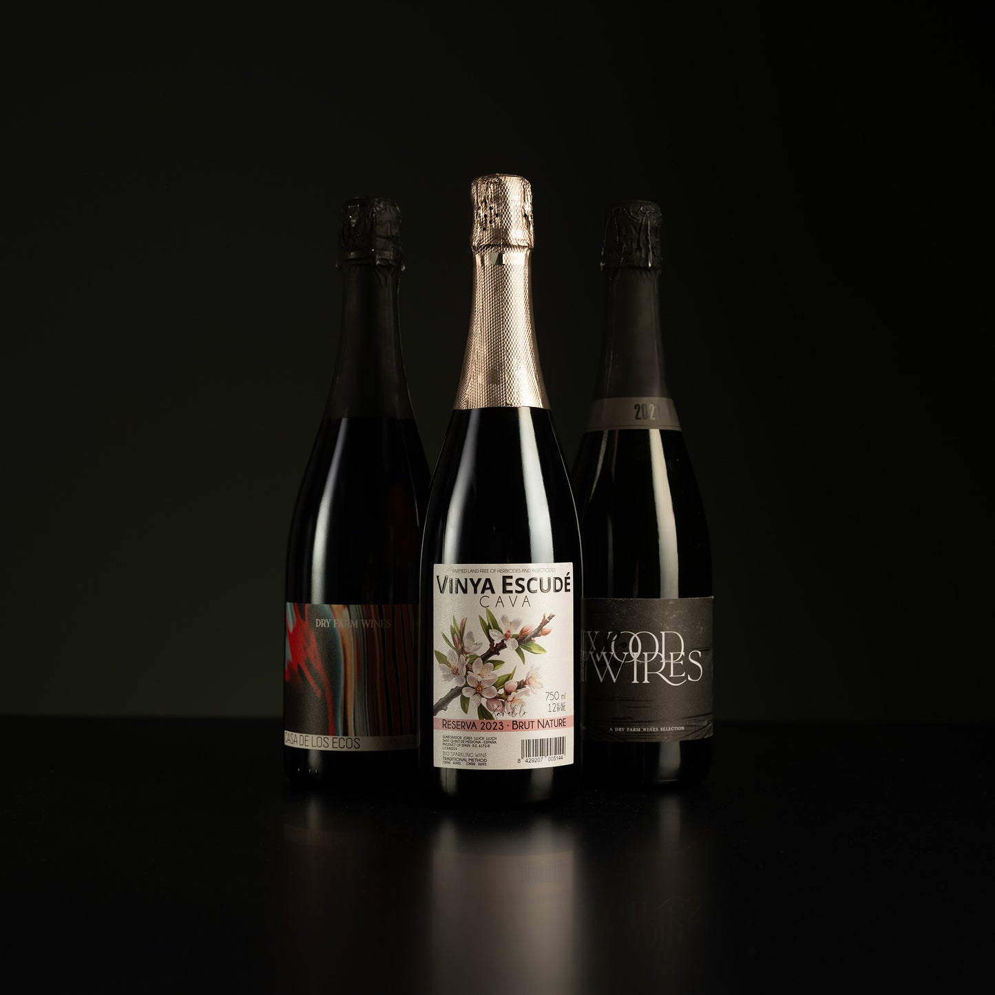 Three wine bottles with visible labels on a black background