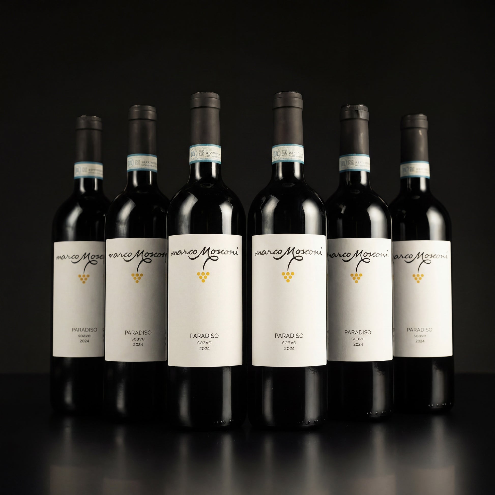 Row of wine bottles with white labels on a black background