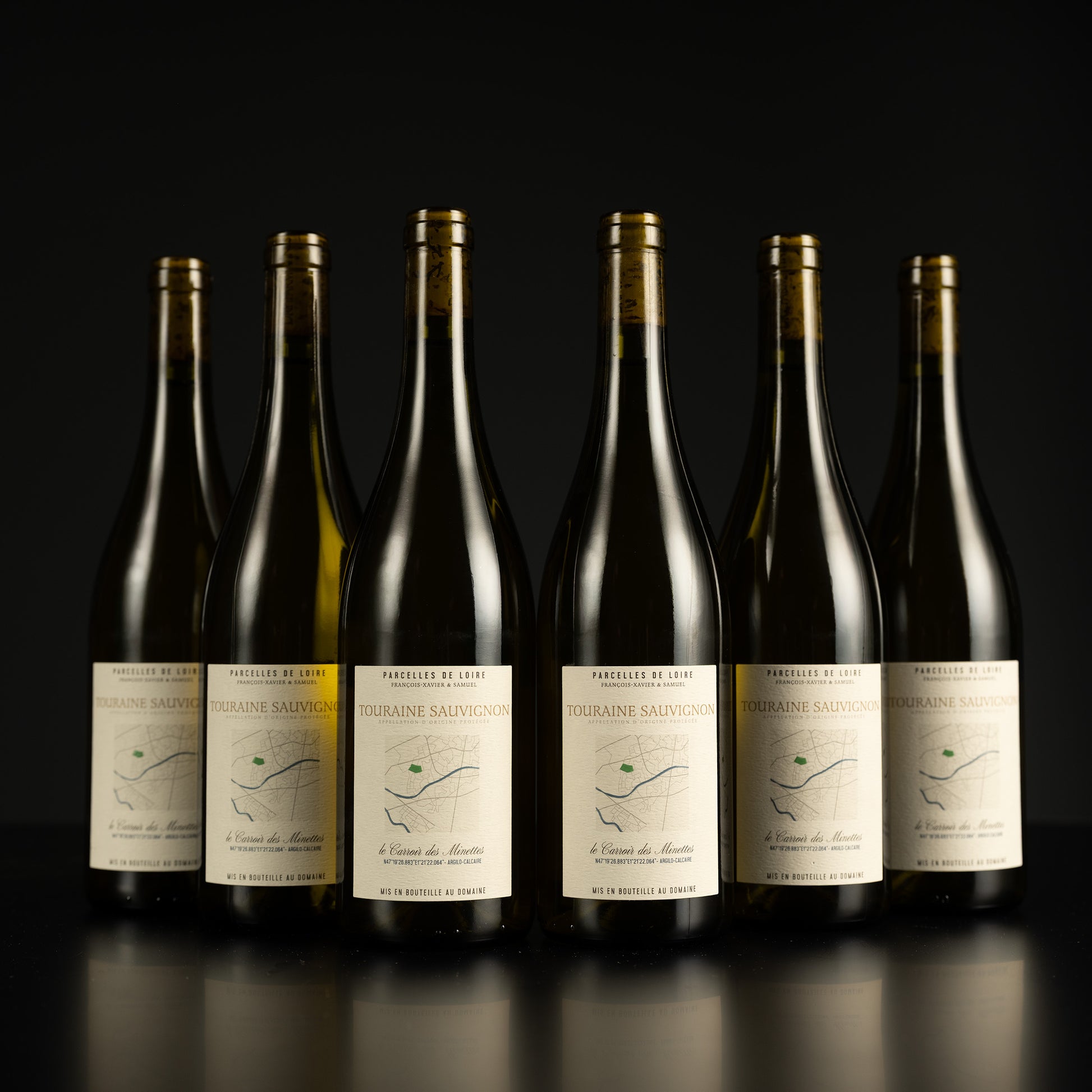 Six wine bottles with labels on a black background