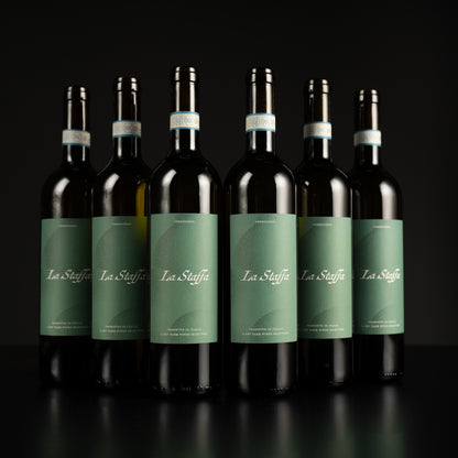 Seven bottles of La Staffa wine arranged in a row on a black background