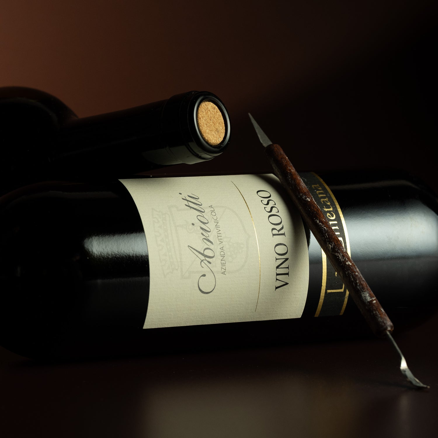 Wine bottle labeled 'Vino Rosso' with a cork and a spoon on a dark background