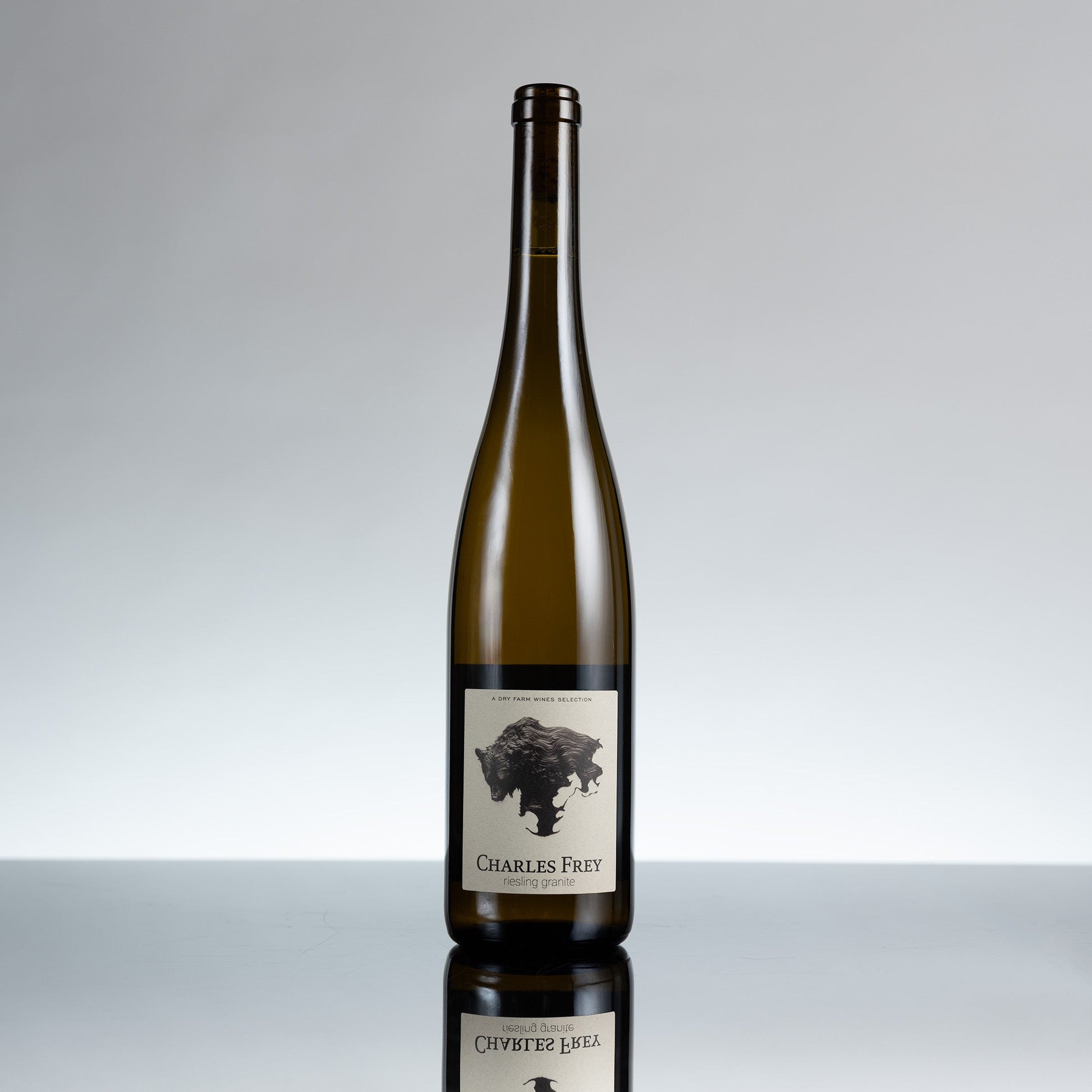 Wine bottle with a label on a reflective surface and gray background