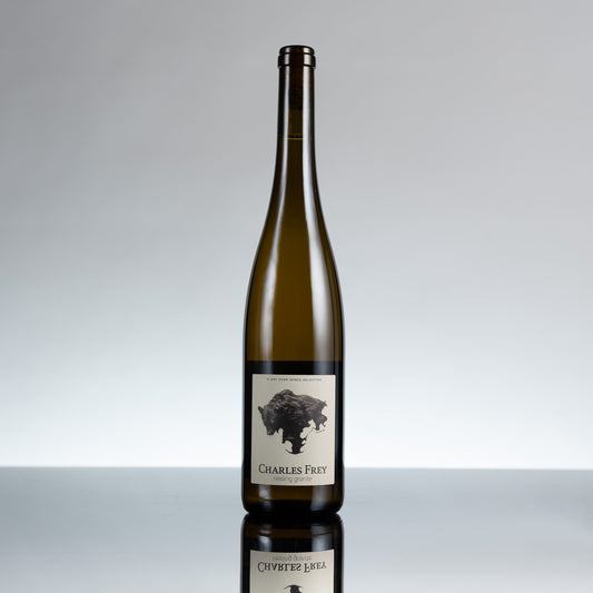 Wine bottle with a label on a reflective surface and gray background