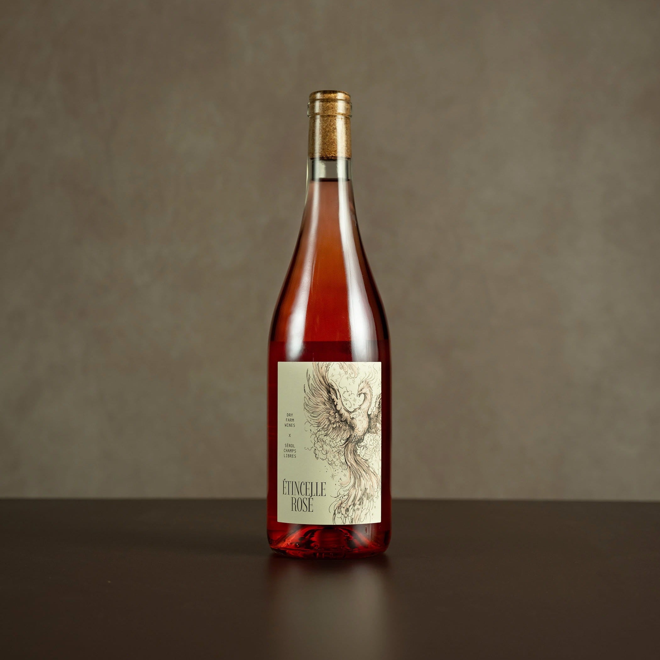 Bottle of wine with a label on a dark surface and brown background