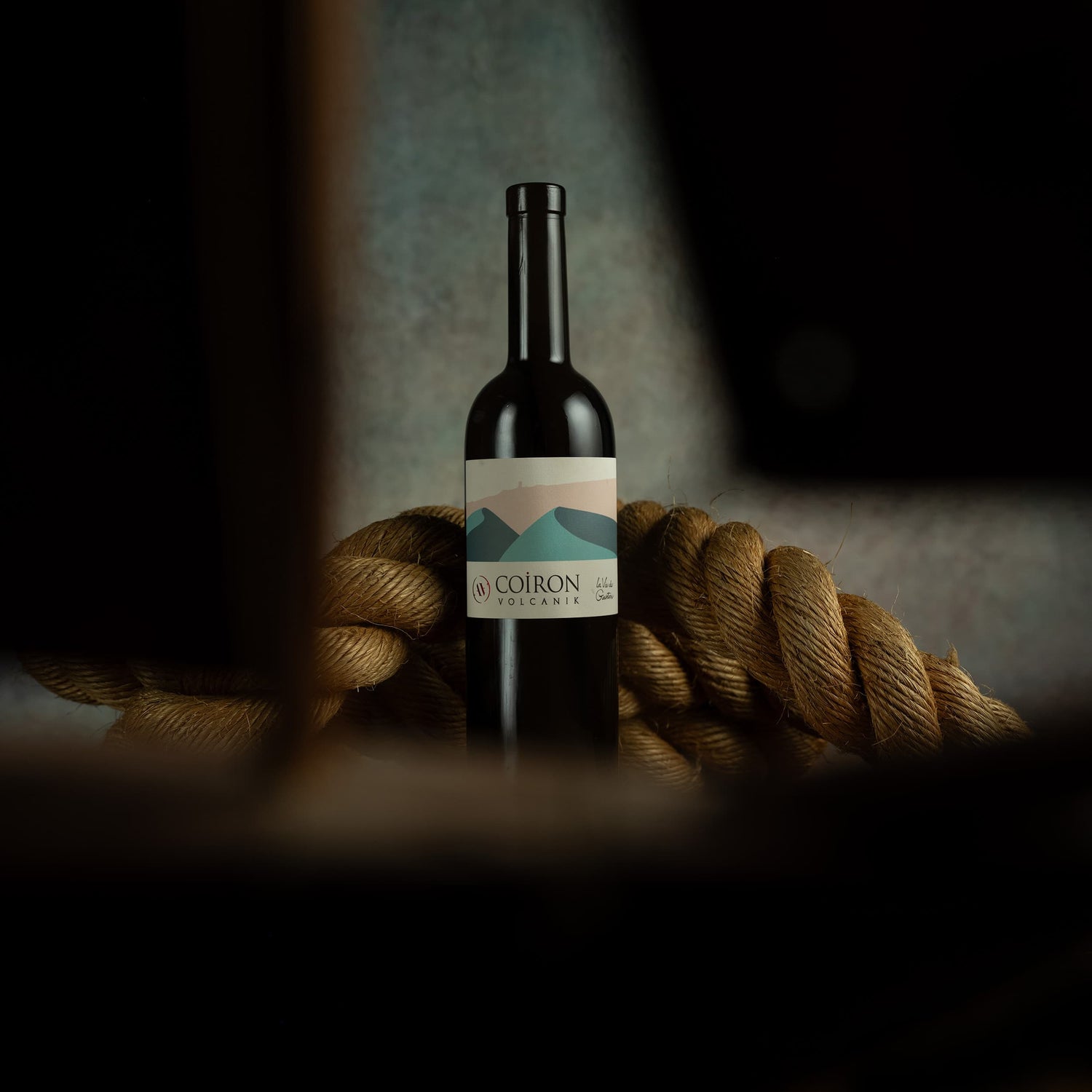 Wine bottle with a label on a textured surface with ropes