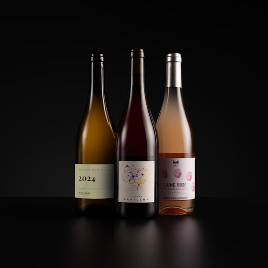Three wine bottles standing upright against a black background, with labels partially visible including '2024', 'PARADISE', and 'LUNE ROSE'.