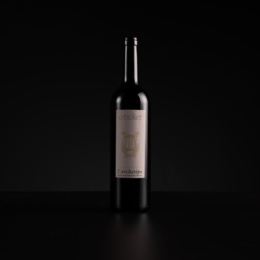 A single dark wine bottle with a cream label and gold lyre logo, standing on a black surface against a black background.