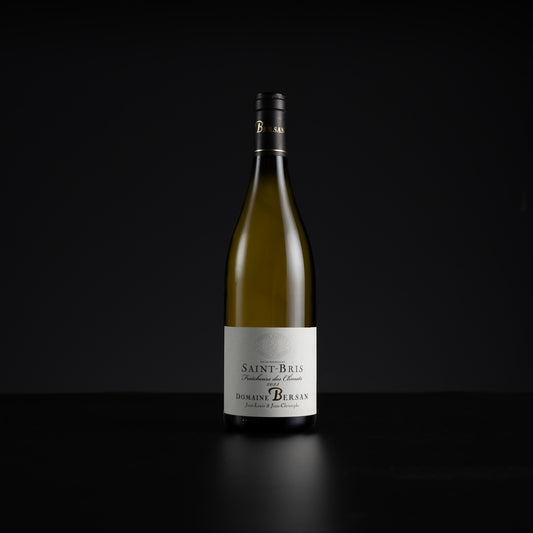 A single bottle of Domaine de Burgan Saint-Bris non-alcoholic white wine, standing upright on a dark reflective surface against a solid black background.