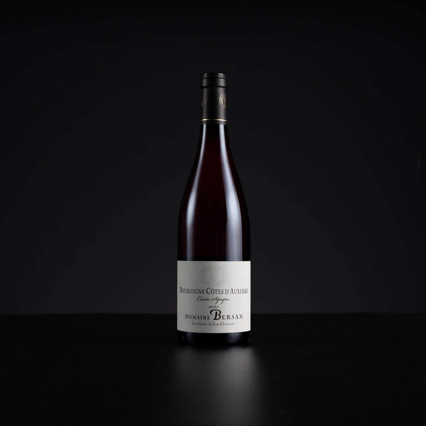 A single bottle of Domains Berlan Bourgogne Cotes d'Auvergne Gran Rey wine, featuring a dark glass bottle with a white label and black cap, set against a solid black background.