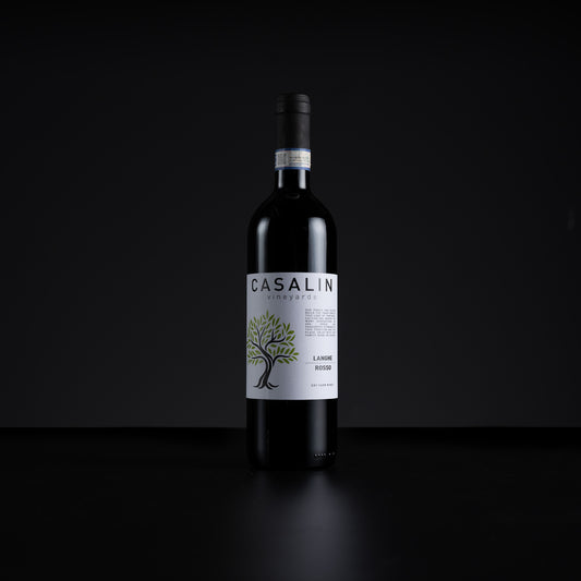 A single bottle of Casalin Vineyards La Vigna Rossa red wine stands centered against a dark black background. The bottle is dark glass with a white label featuring a green tree illustration and black text.