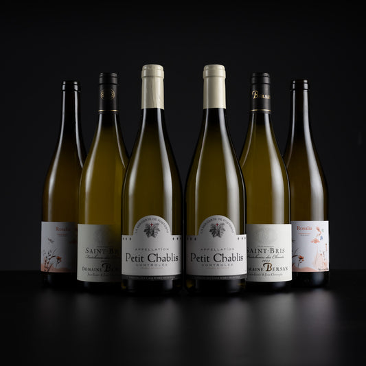 Six white wine bottles from the brand Rescadis, including Petit Chablis and Saint-Bre, arranged in a row against a dark studio background.