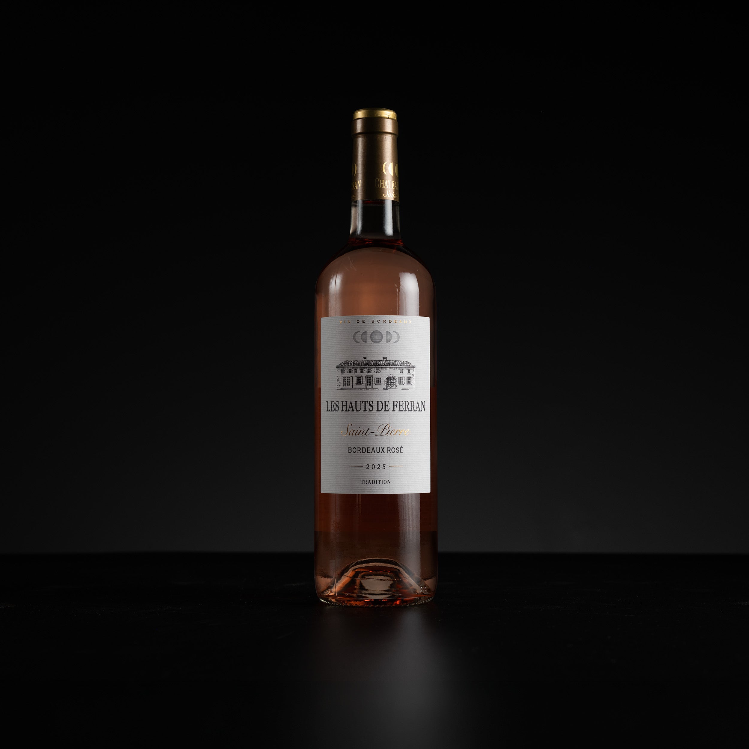 A bottle of Les Hauts de Ferran Rose Pink Bordeaux Rosé wine, standing upright on a dark reflective surface against a solid black background.
