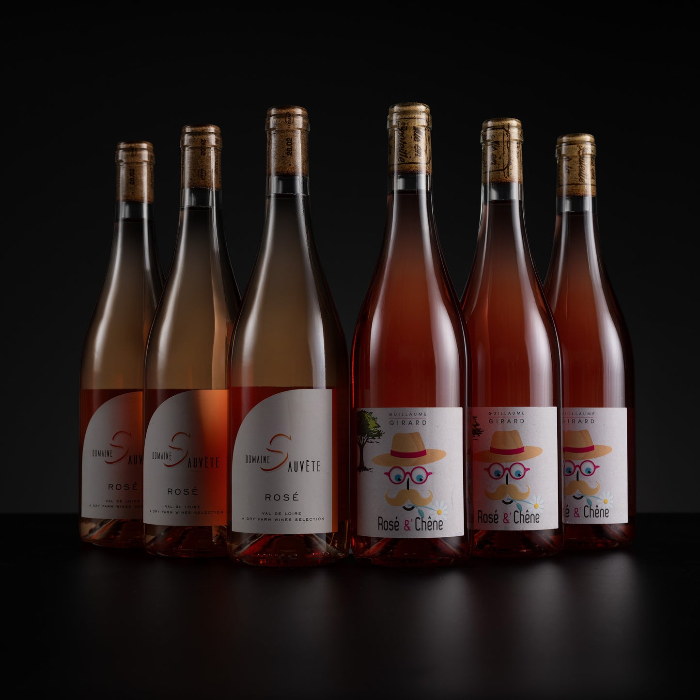 Six bottles of Rosé Santeçe rosé wine arranged in a row against a black background. The bottles are filled with pale pinkish-rose liquid and have white labels with a cartoon mustache wearing a cowboy hat and sunglasses.