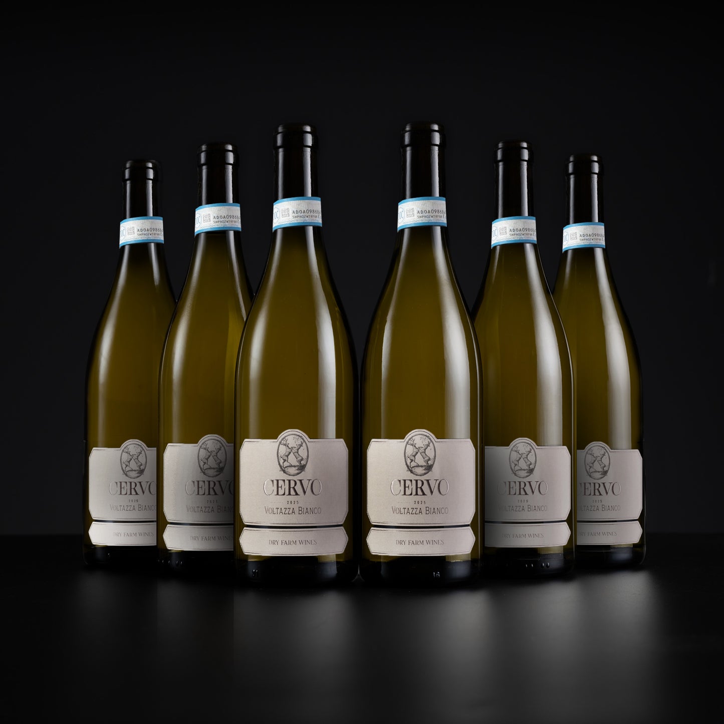 Six bottles of white wine arranged in a row on a dark reflective surface against a black background. The center bottle is fully visible and in focus, while the bottles on the left and right are slightly blurred.