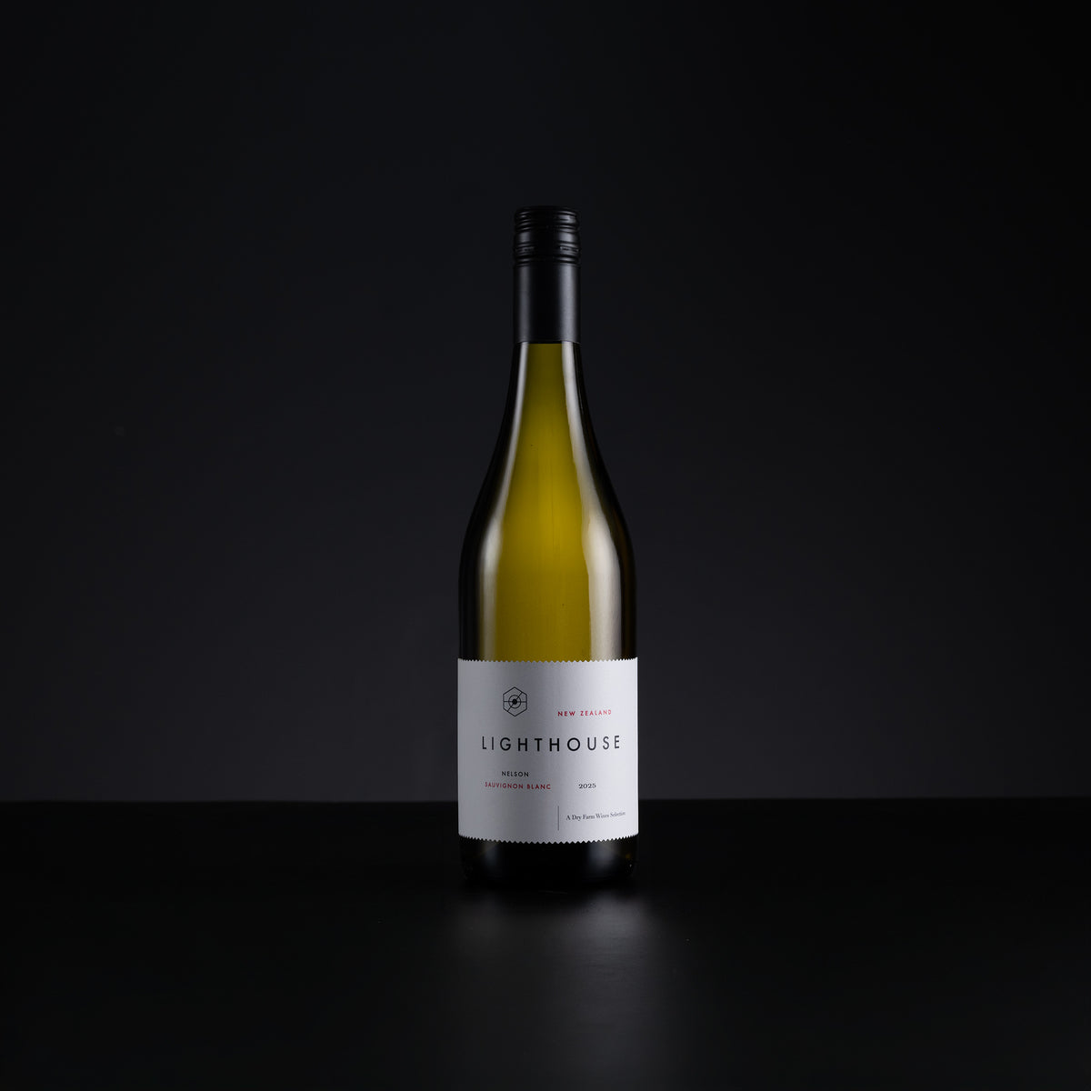 A single bottle of Lighthouse New Zealand Sauvignon Blanc wine, standing upright on a dark reflective surface against a solid black background.