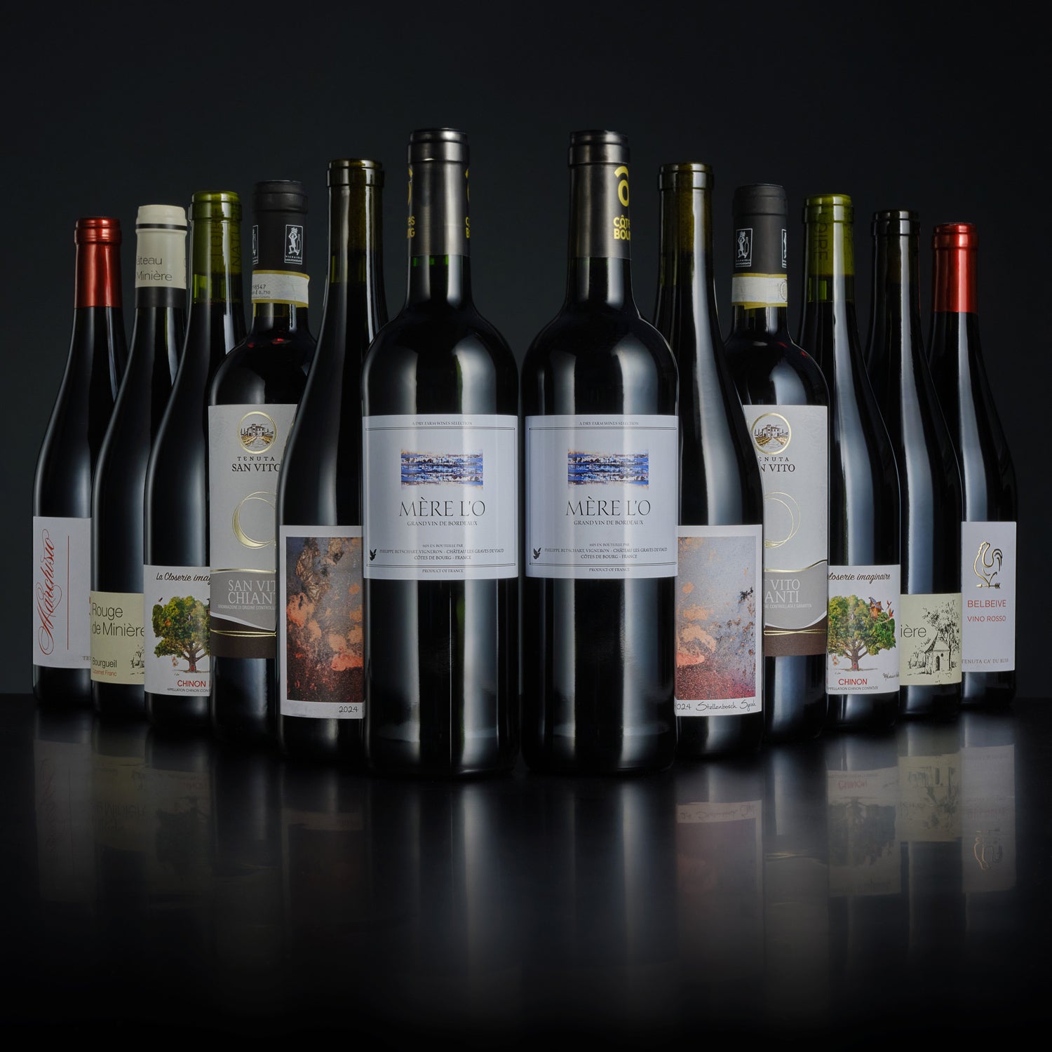 Collection of wine bottles with various labels on a dark background