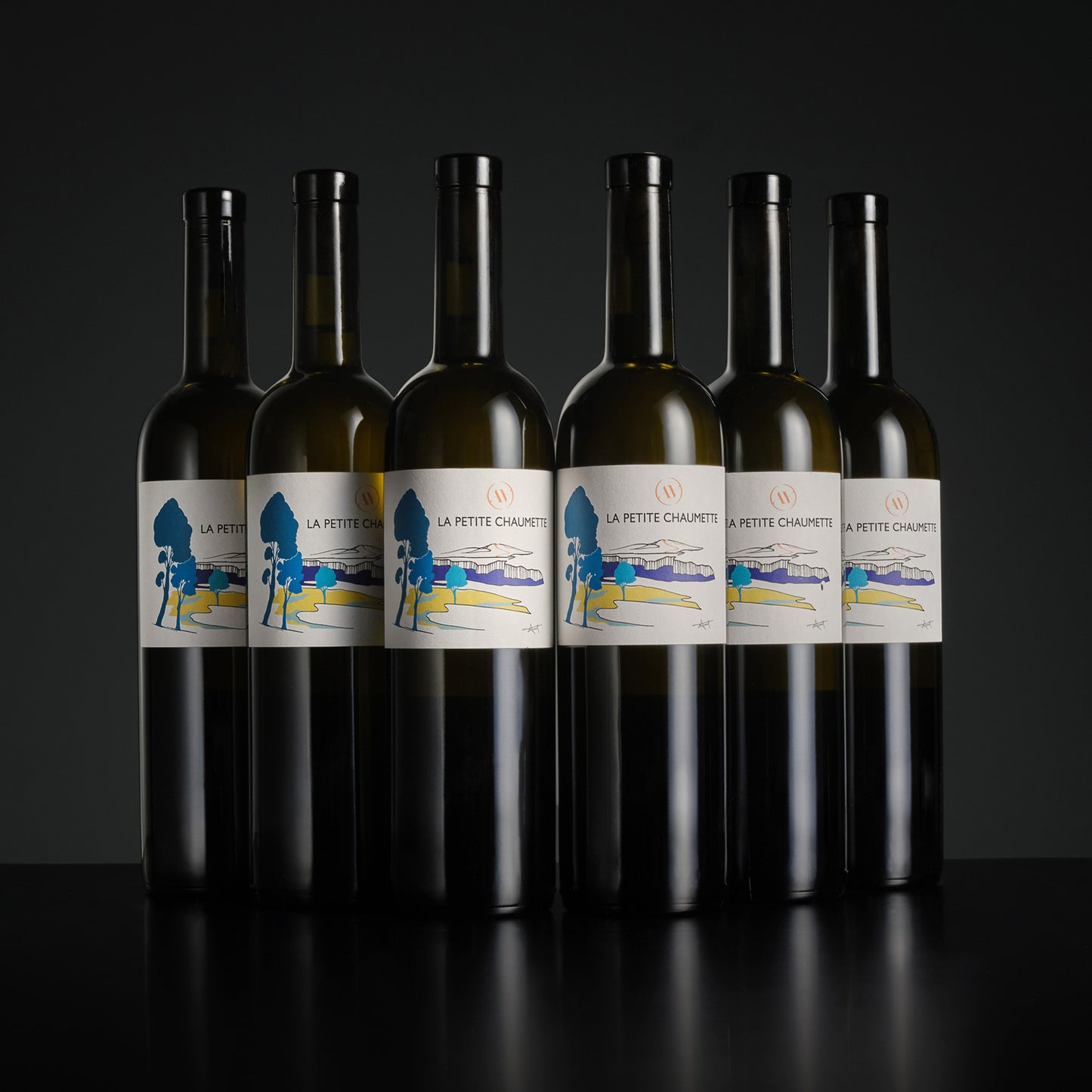 Six bottles of La Petite Chaumette wine arranged in two rows on a dark background