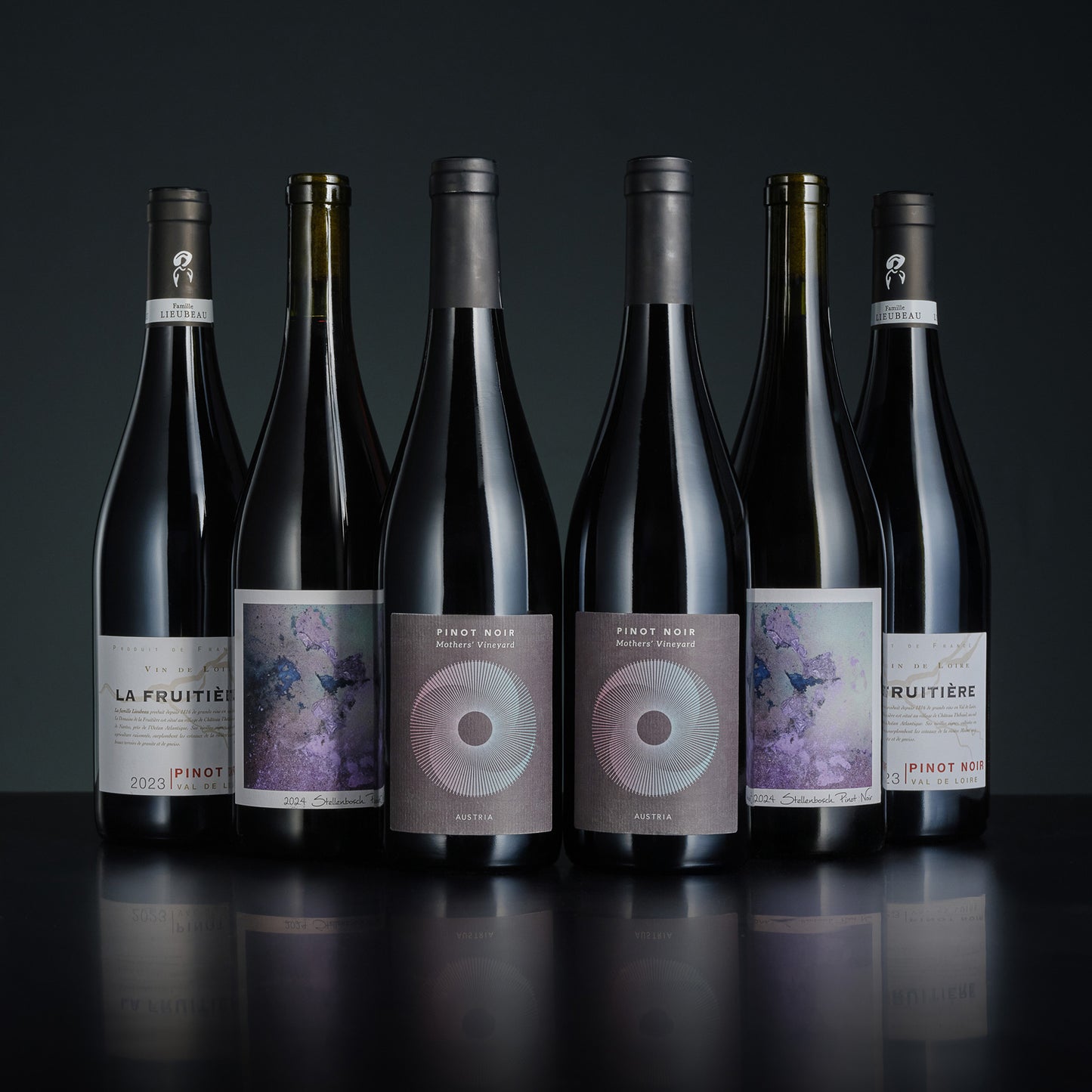 Six bottles of wine with labels on a dark background