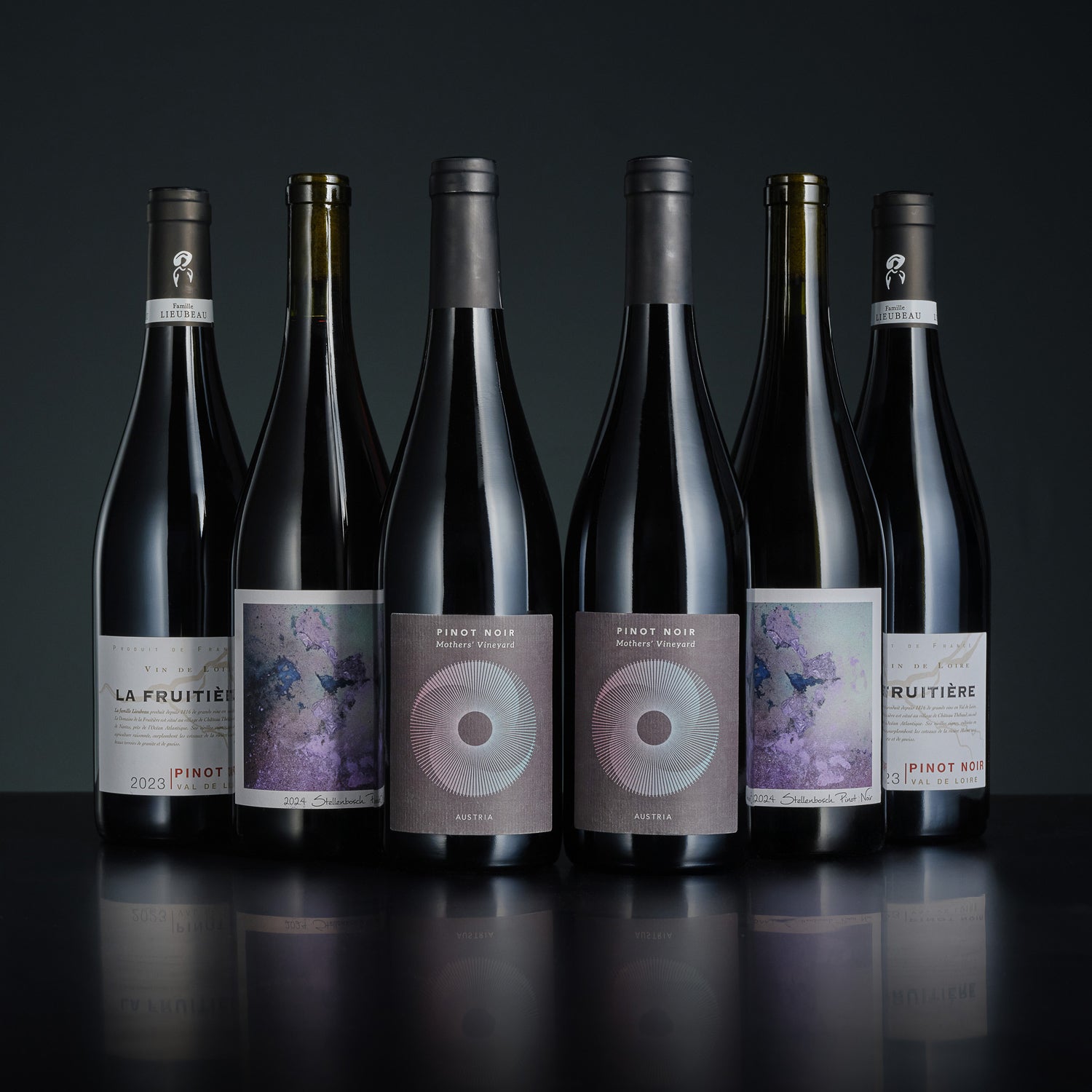 Six bottles of wine with labels on a dark background