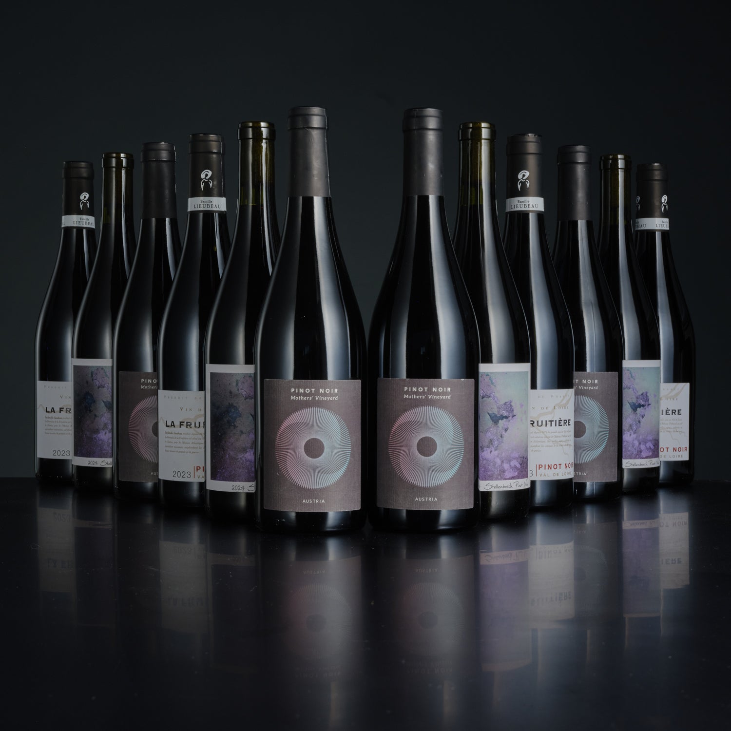 Row of wine bottles with labels on a dark background