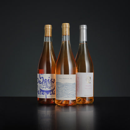 Three wine bottles with labels on a dark background